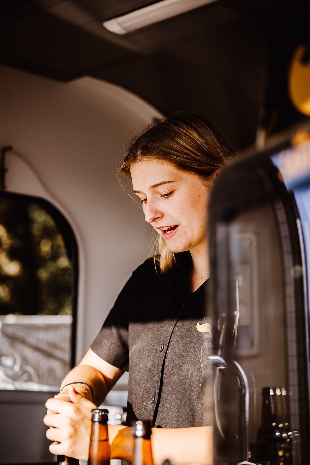 A member of the Santé team serving Gold Mustache from the bar van at an event